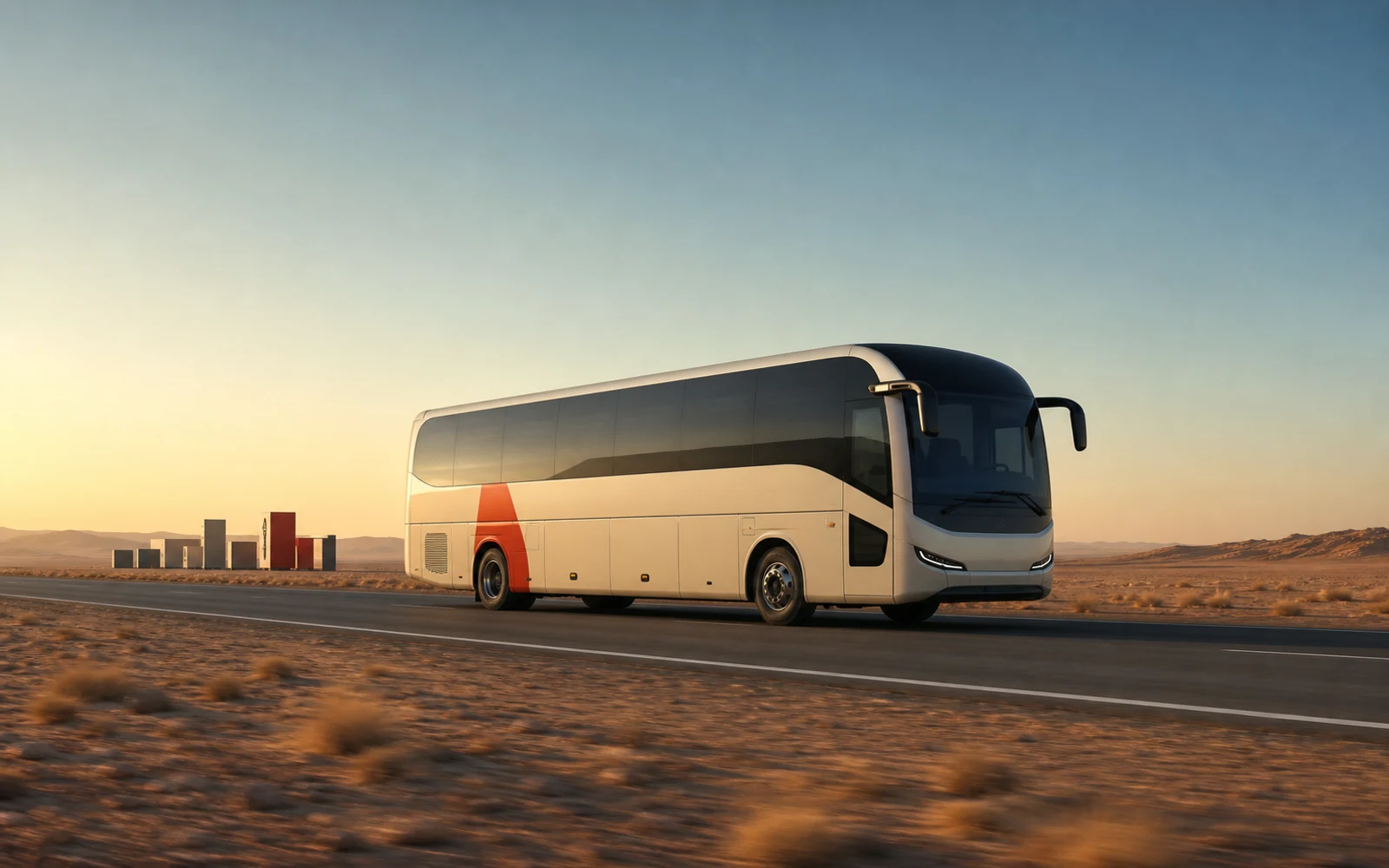 A cream electric coach with a vermilion accent travelling through an open desert landscape at dawn.
